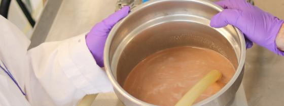 scientist treating brown liquid - NSF